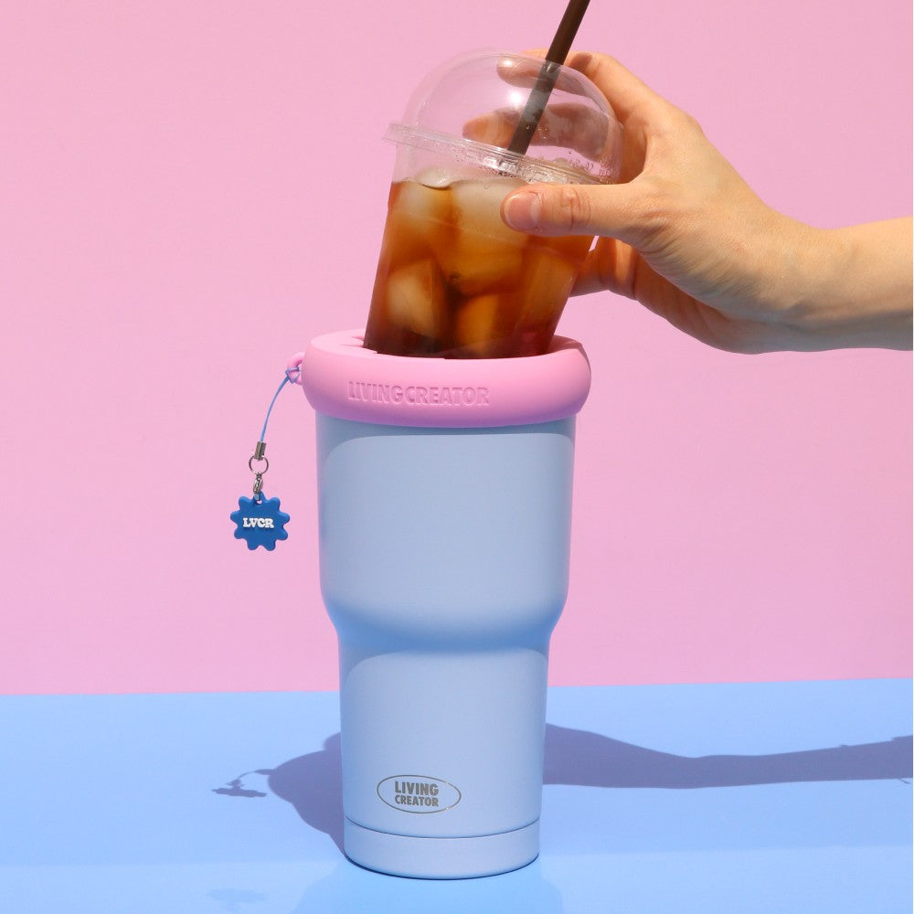 Pastel blue KEEPER TUM with an iced coffee, held in one hand